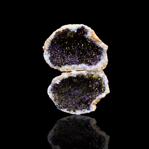 Geode split open revealing a purple interior on a black background