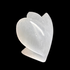 Side view of 10cm carved selenite angel crystal showing natural stone detail on black background