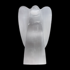 Natural selenite angel lamp carving on a black background
