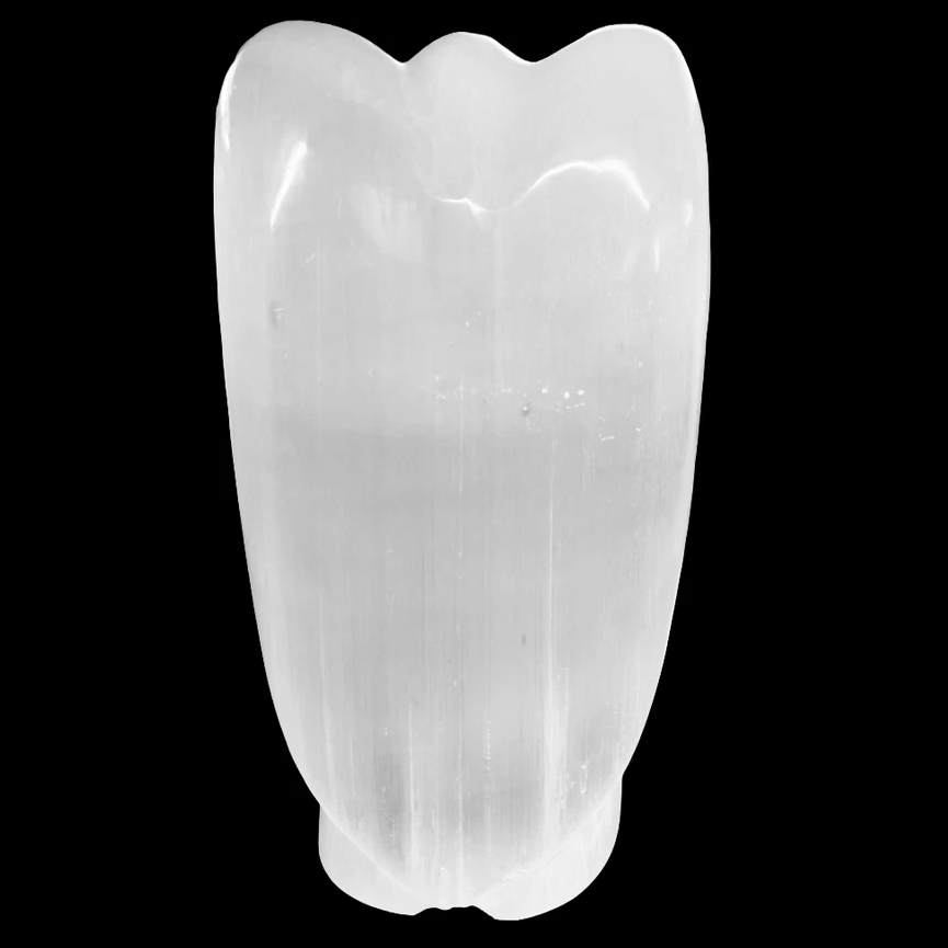 Back view of a natural selenite angel lamp unlit on a black background
