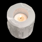 Lit tealight inside natural selenite candle holder with polished top and fibrous Moroccan stone texture