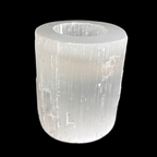 Natural selenite candle holder with polished top and raw sides carved from Moroccan selenite on black background