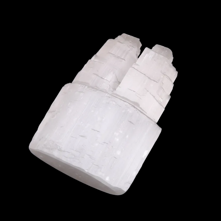Angled view of polished selenite double mountain tower crystal showing carved natural striations on black background