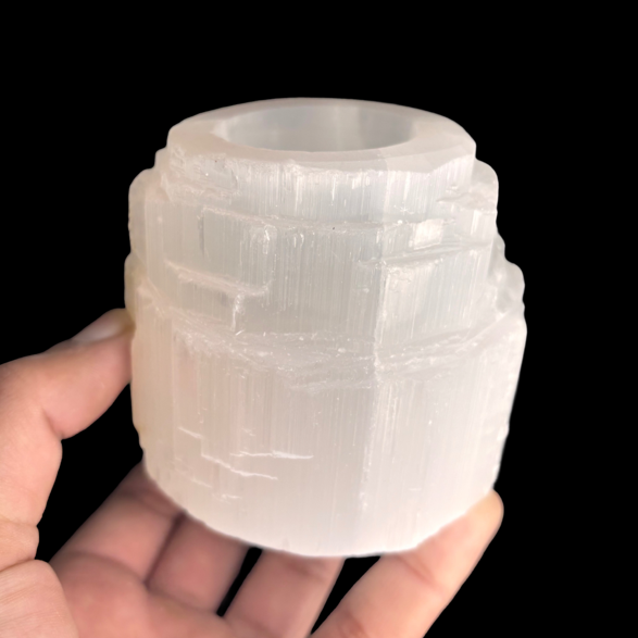 Natural selenite tealight candle holder displayed in hand for size reference